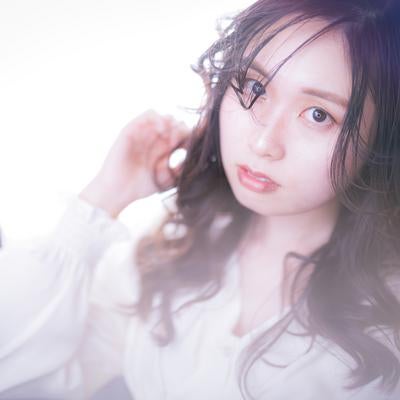 ゆるふわ巻き髪をした眼鏡をかけた若い女性のビューティーの写真