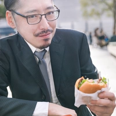 ハンバーガーを食すグルメライターの写真