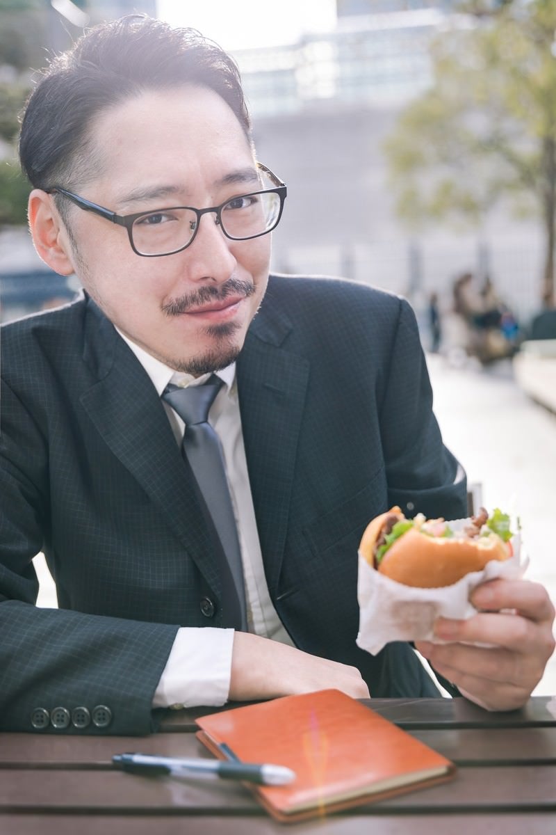「ハンバーガーを食すグルメライター」の写真［モデル：ゆうせい］