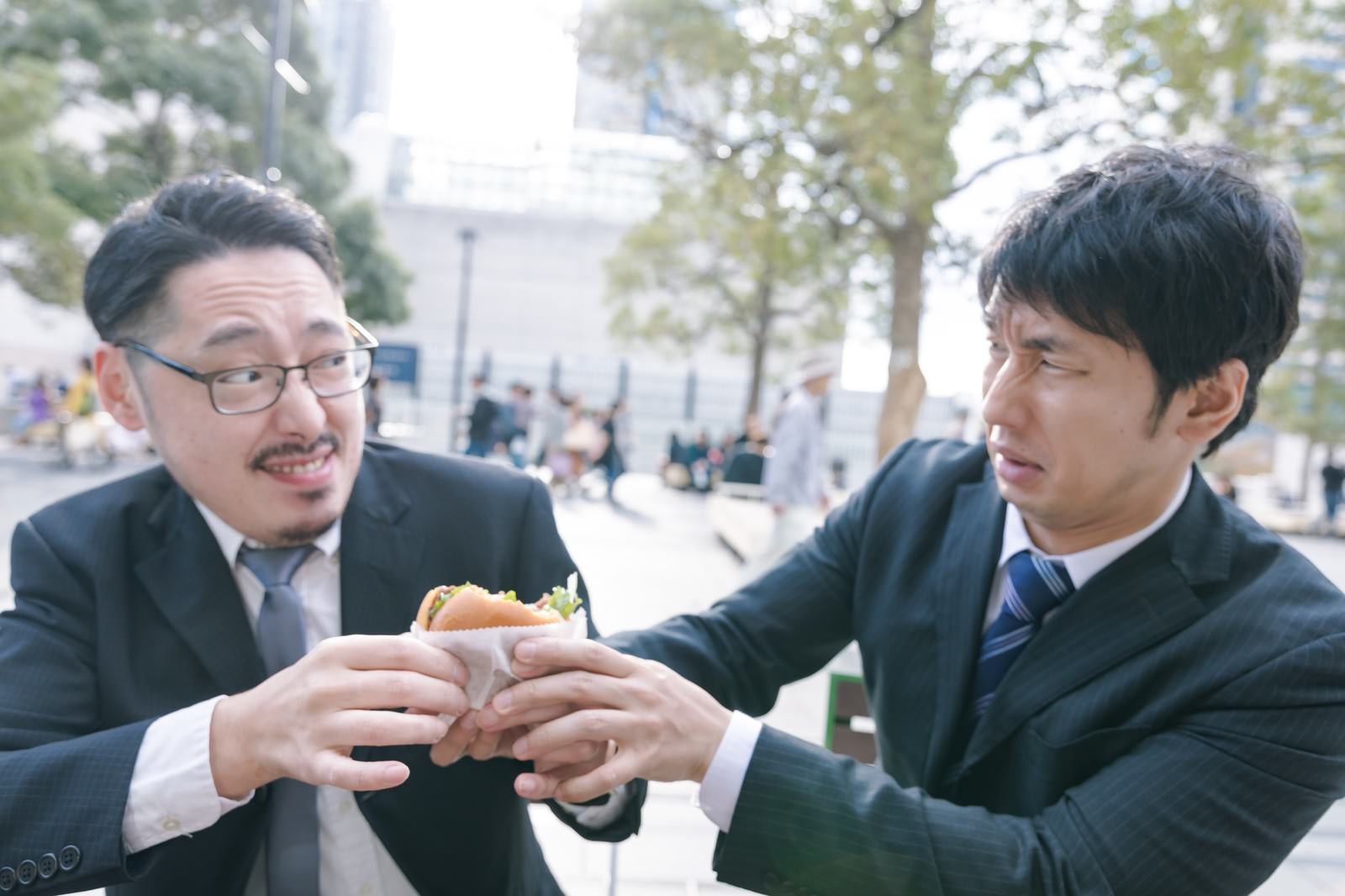 「絶品ハンバーガーを奪い合う上司と部下」の写真［モデル：大川竜弥 ゆうせい］
