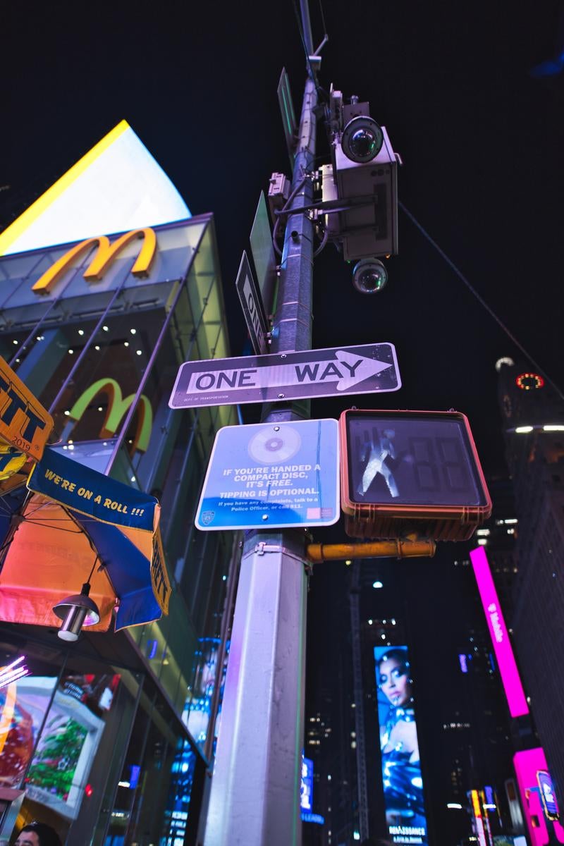 「タイムズスクエアの夜景とワンウェイの標識」の写真