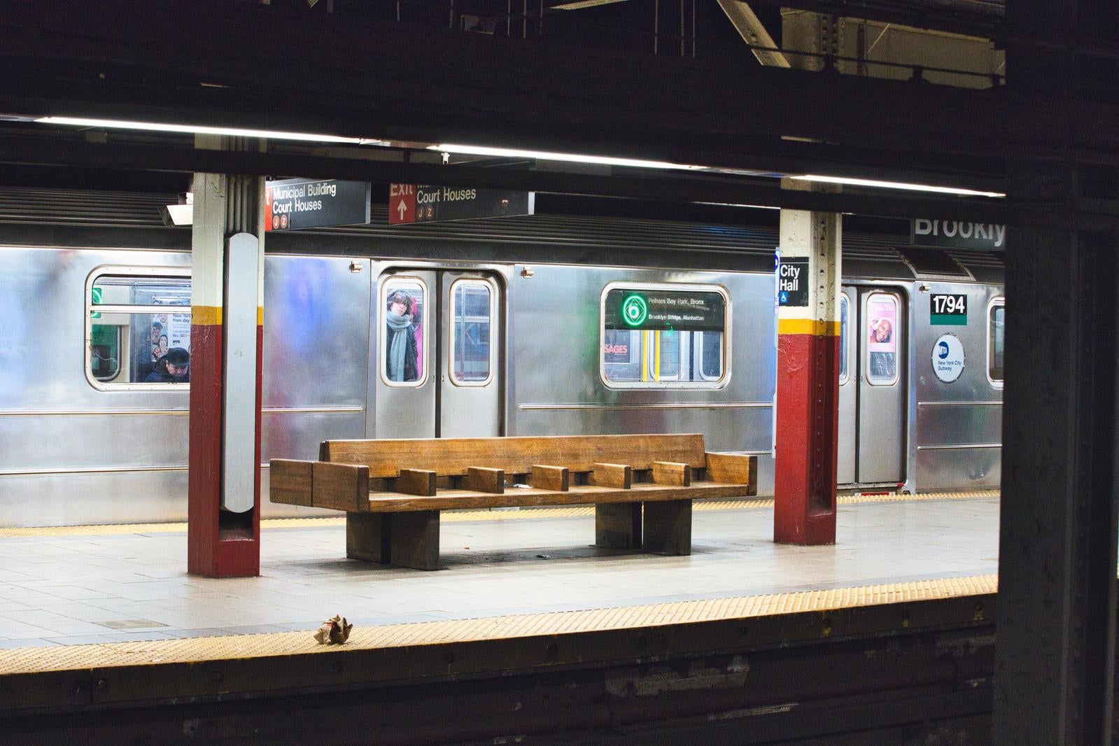 「ニューヨークの移動の中心、地下鉄ホームのベンチでの一時」の写真