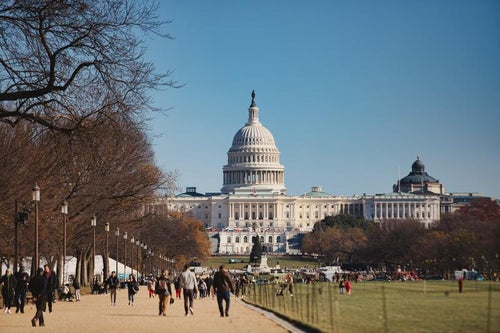 ワシントンD.C.の遊歩道を行き交う人とアメリカ国会議事堂の写真