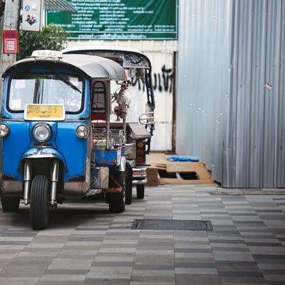 路地裏に佇む青いトゥクトゥクのある日常風景の写真