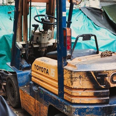 作業現場に置かれた使い込まれた重機の写真