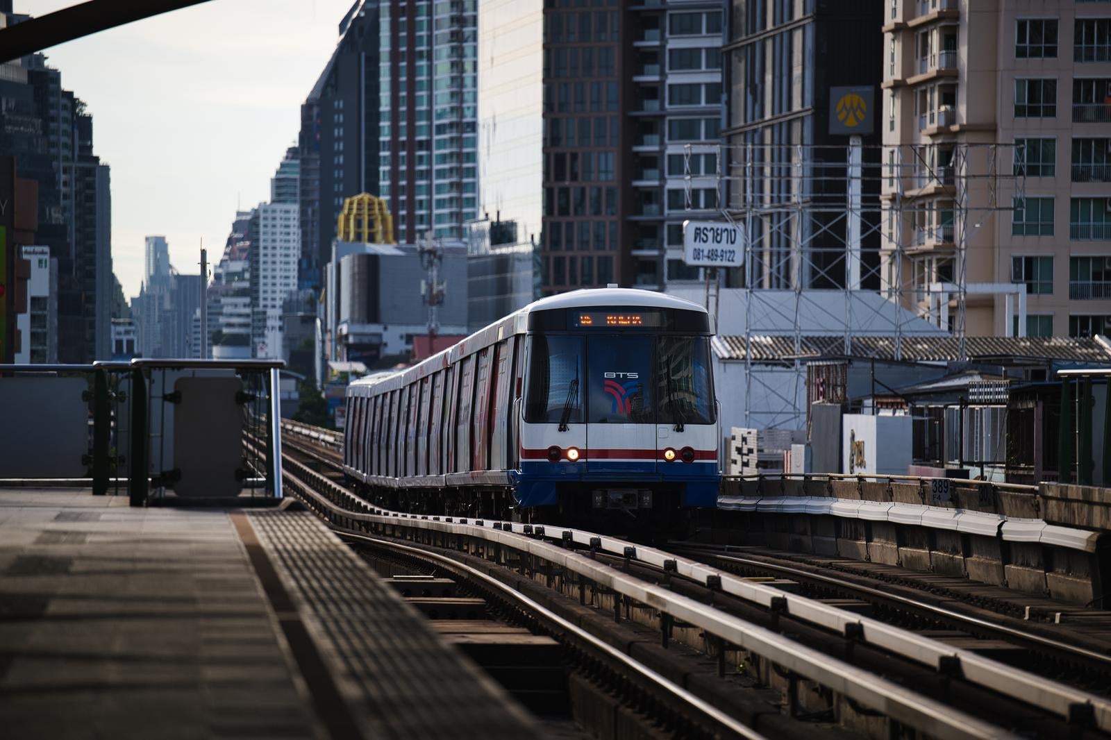 BTS Skytrain vehicles running against the backdrop of the high-rise buildings in Bangkok - free stock photo