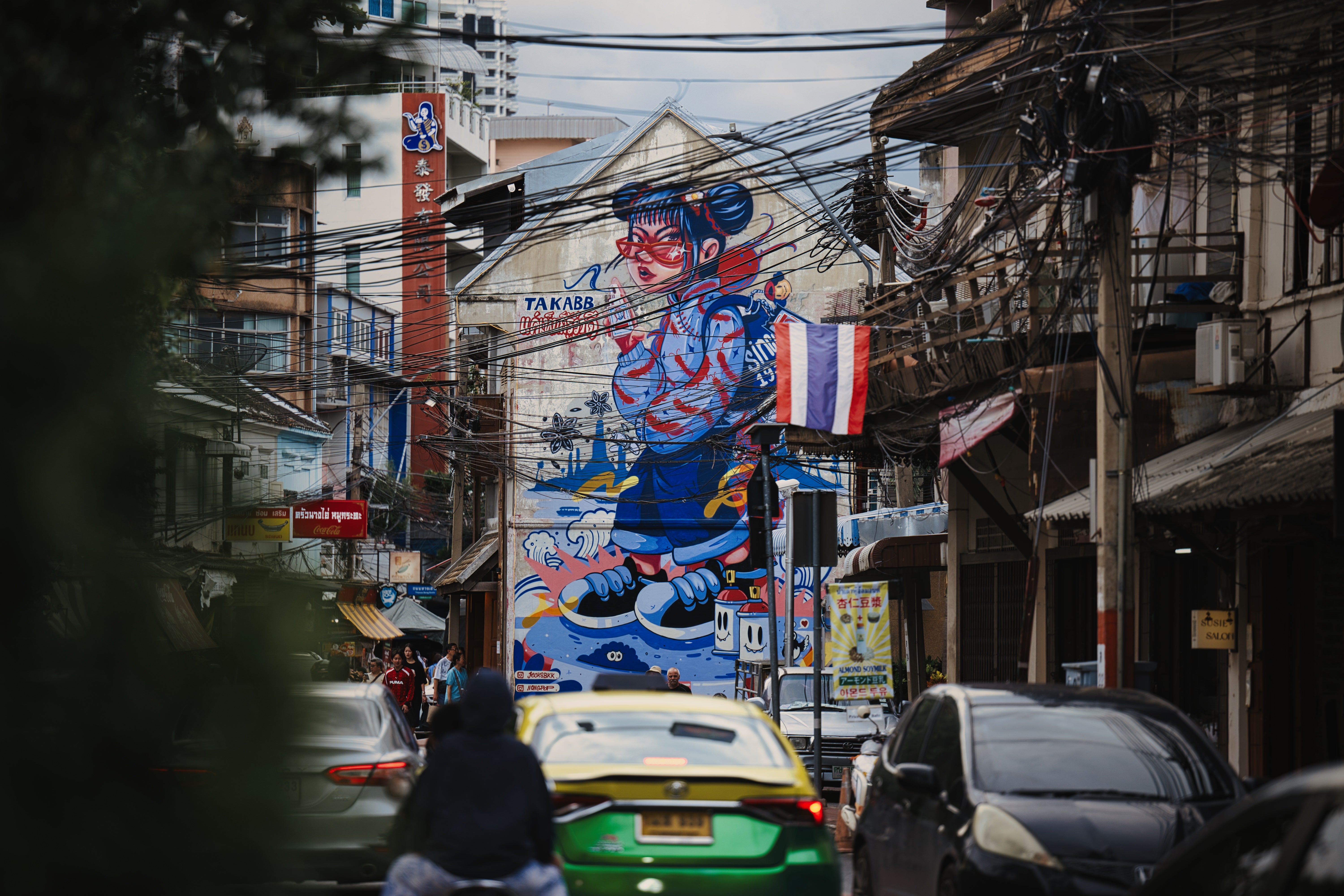 壁一面に大きなストリートアートが描かれた狭い路地の素材