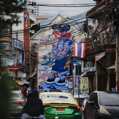 壁一面に大きなストリートアートが描かれた狭い路地の写真