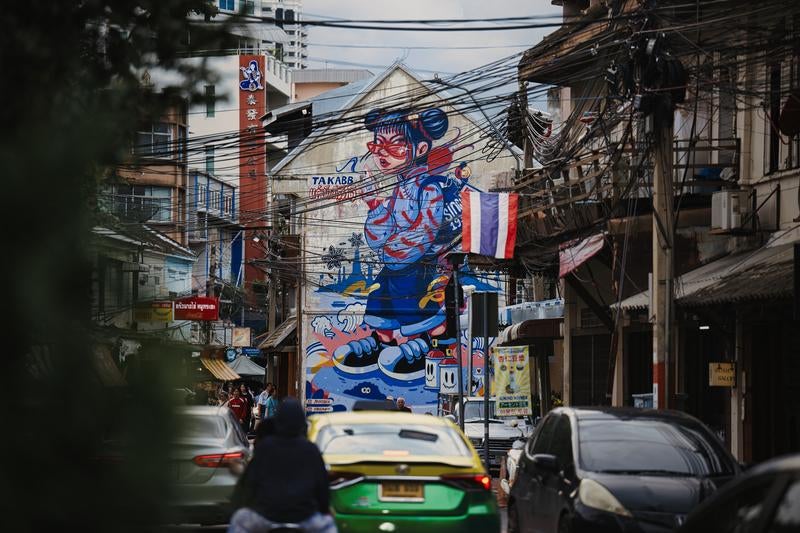 壁一面に大きなストリートアートが描かれた狭い路地