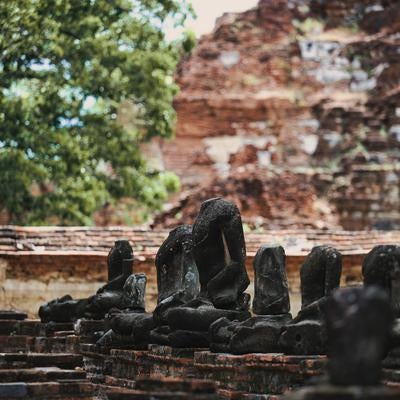 首を失った仏像が並ぶ遺跡の写真