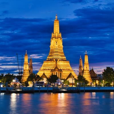 オレンジ色にライトアップされたワット・アルンとチャオプラヤー川の夜景の写真