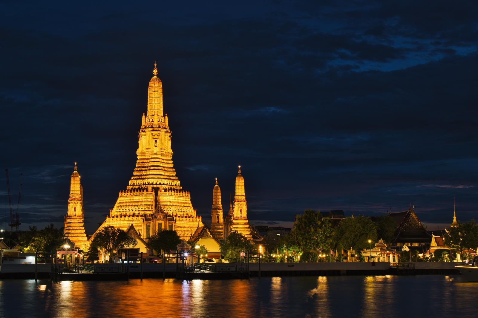 The Night View of Wat Arun Illuminated in Golden Light Against the Dark Blue Night Sky - free stock photo
