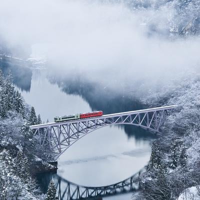 冬の第一只見川橋梁を通過する列車と雪景色の写真