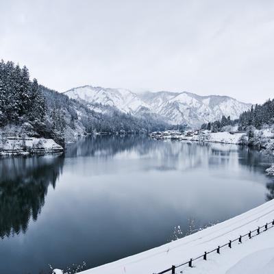 只見線沿線の雪山と川が映る冬景色の写真