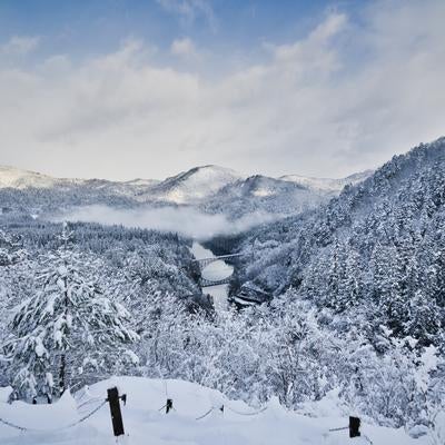 雪に覆われた山々と第一只見川橋梁の冬景色の写真
