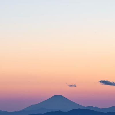 夕焼け空に浮かぶ富士山のシルエット、夜景の街明かりと共に映える情景の写真