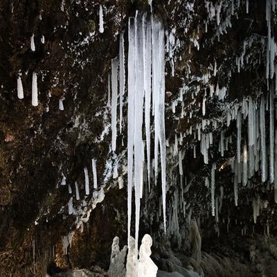 岩壁から垂れ下がる氷柱の造形の写真