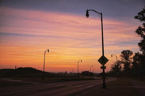 初夏の朝焼けと街灯のシルエットの写真