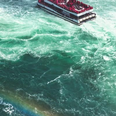 流れの強いナイアガラ川の観光船と虹の写真