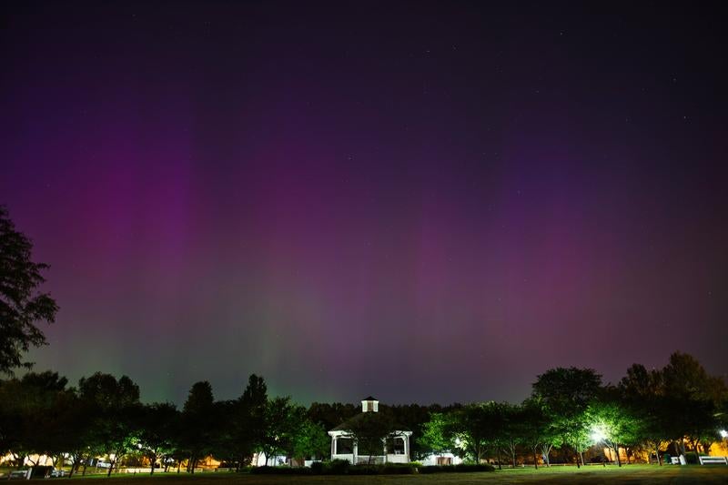 夜空に広がる紫色のオーロラと公園のガゼボ