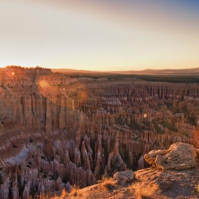 夕陽の光芒に照らされるブライスキャニオンの峡谷の写真