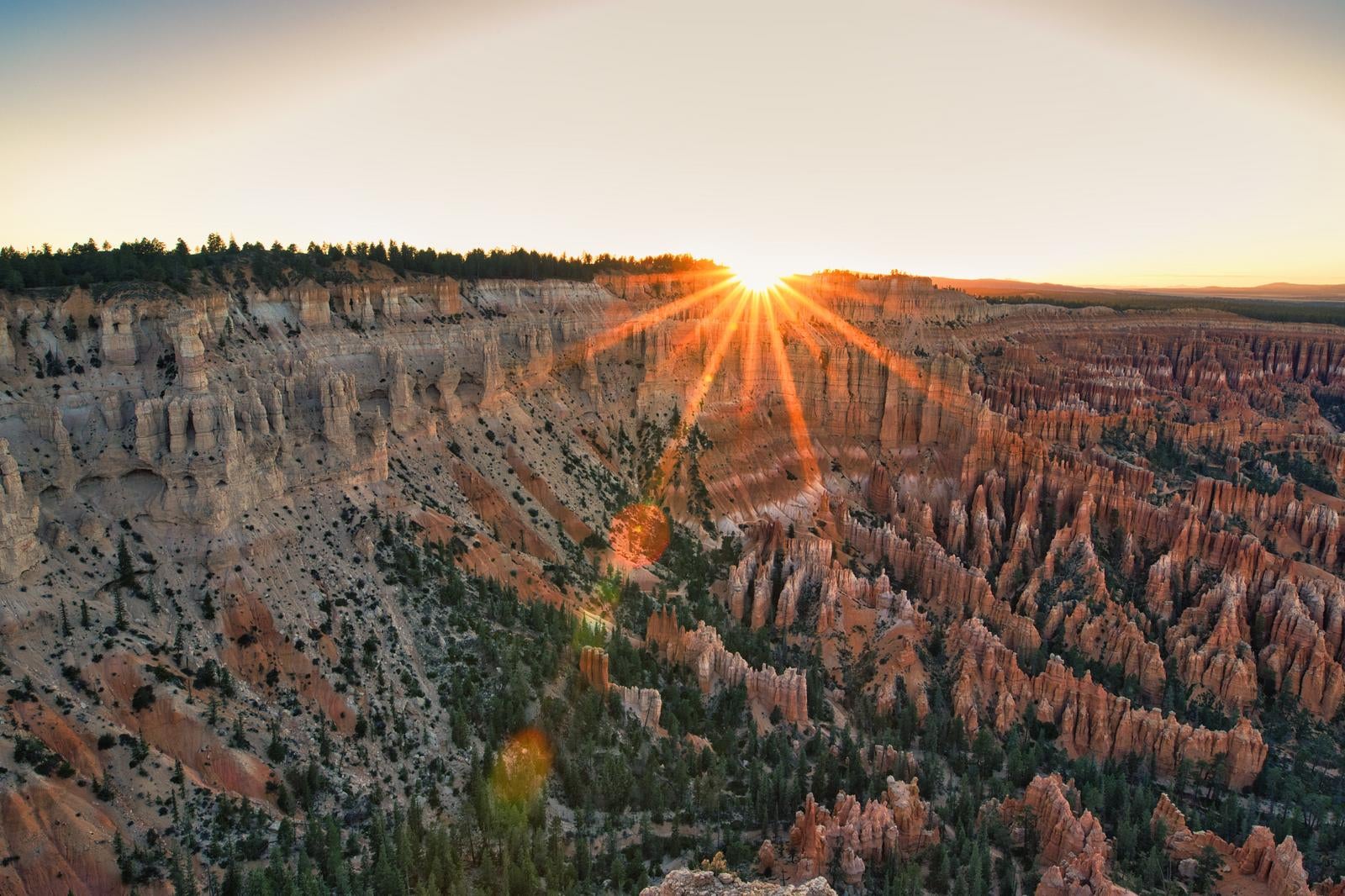 朝日が照らすブライスキャニオンの峡谷。無数の岩柱と光線が放射状に差し込む風景