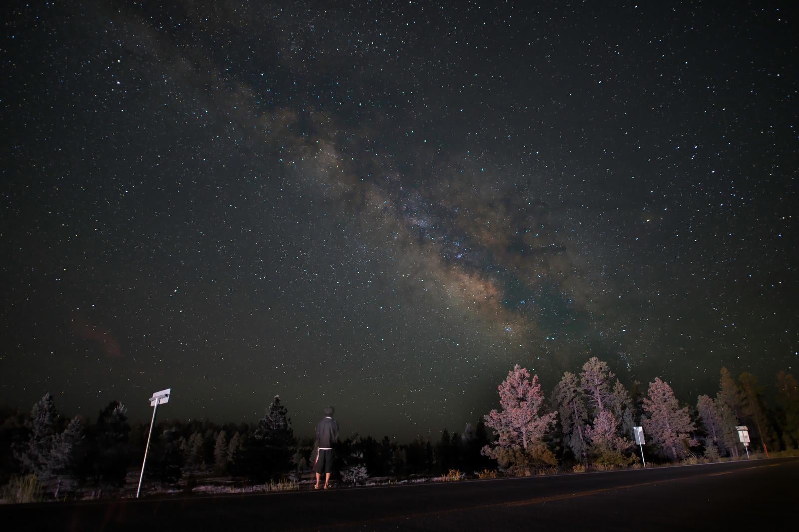 ブライスキャニオン国立公園の上空に光る天の川を見上げている人