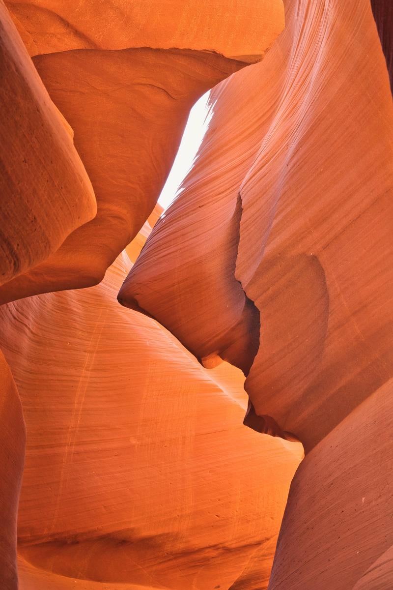 アンテロープキャニオンの砂岩岩壁。褐色と朱赤色が層状に積み重なり、上から光が差し込む