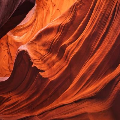 アンテロープキャニオンの赤茶色に輝く砂岩の層状岩壁の写真