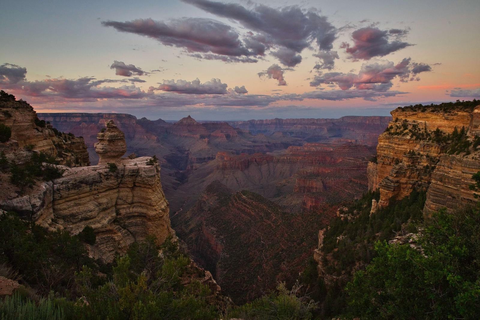 夕暮れ時のグランドキャニオン、赤紫色の雲と岩肌の峡谷