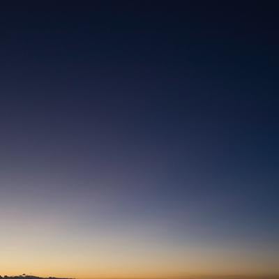 薄暗い空に浮かぶ三日月とグランドキャニオンの地平線の写真