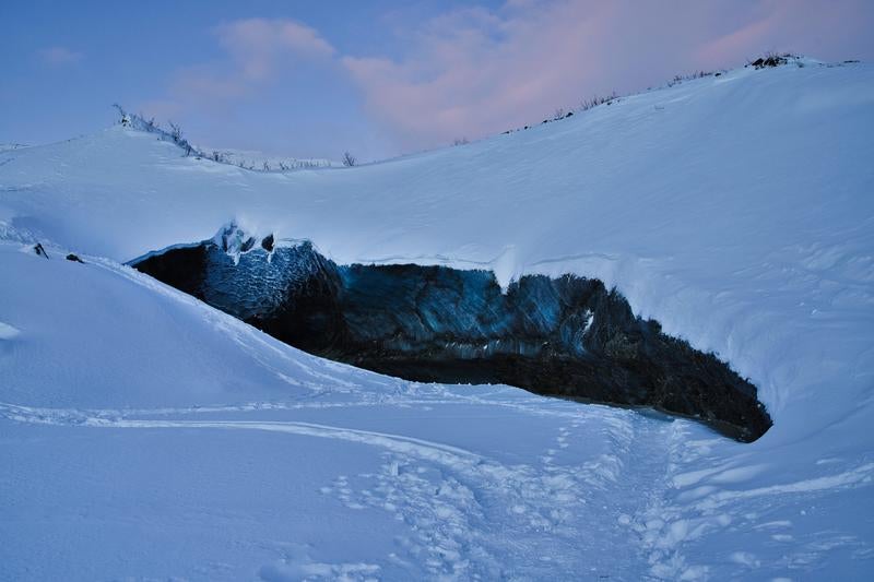 雪山に開いた氷の洞窟の写真