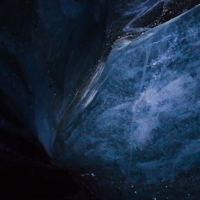 洞窟内の暗く青い氷壁の写真