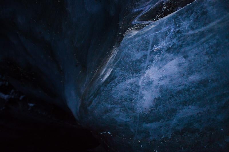 洞窟内の暗く青い氷壁の写真
