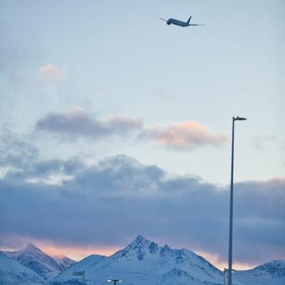 冬の夕暮れに映える雪山と飛行機の写真