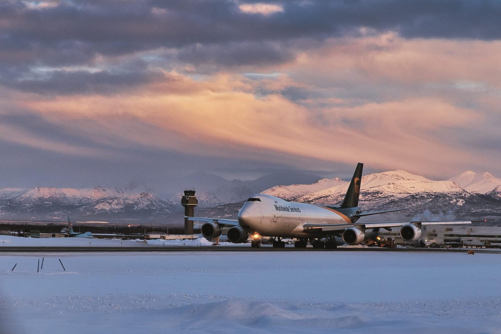 「冬の夕暮れに映えるUPS貨物機と雪景色」の写真