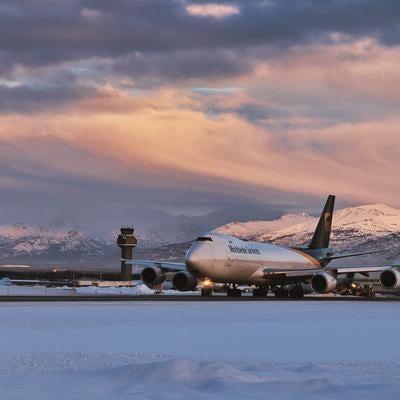 冬の夕暮れに映えるUPS貨物機と雪景色の写真