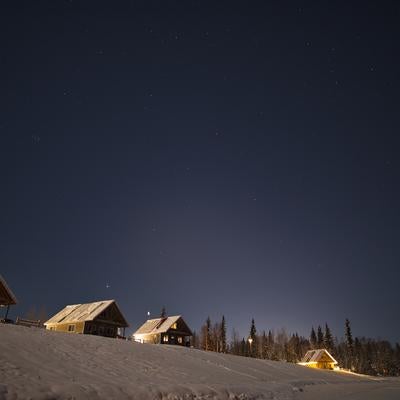 冬の星空の下で静かに佇む山小屋の写真
