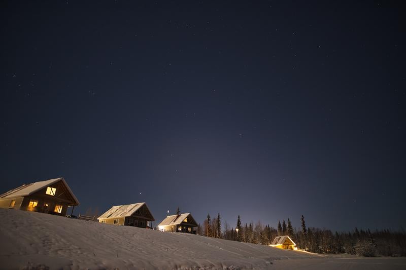 冬の星空の下で静かに佇む山小屋の写真