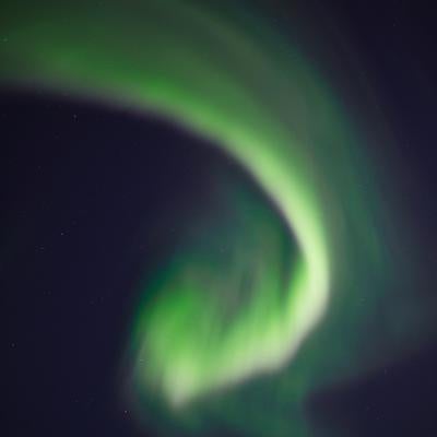 夜空に舞う緑色のオーロラの写真