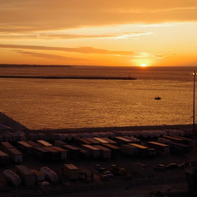 港から眺める沈む夕日の写真