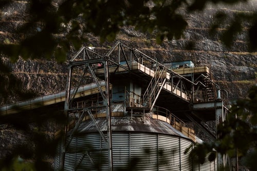 木々の隙間から見た工場（奥多摩）の写真