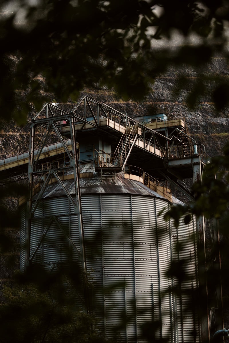 「茂みの向こうに見える古い工場（採石場）」の写真