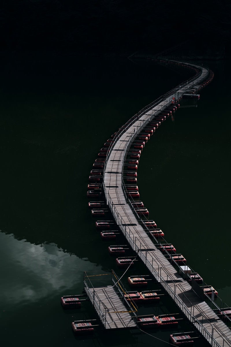 「ダム湖に掛かる曲がりくねった浮橋（奥多摩）」の写真