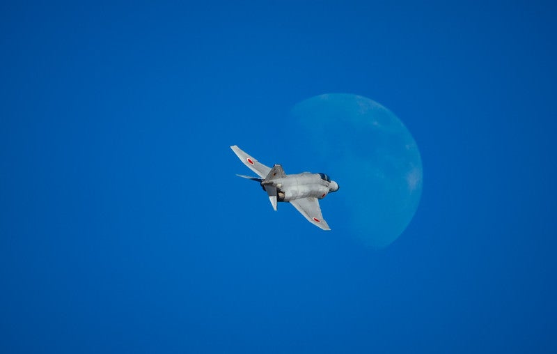 月に向かって飛行するF-4戦闘機の写真