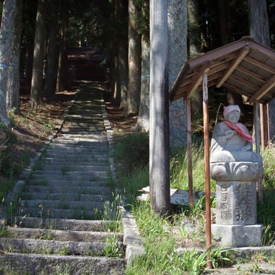 山のお社に続く階段と入り口の石仏の写真