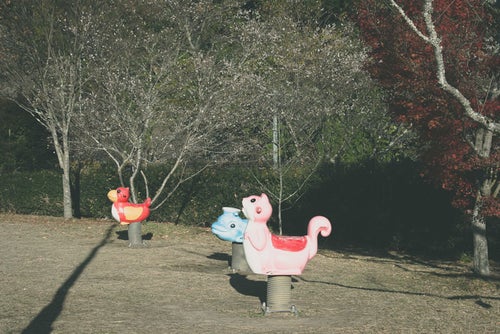 公園に設置された動物型のスプリング遊具の写真