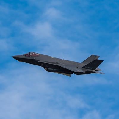 白い雲が浮かぶ青空を飛行する航空自衛隊のステルス戦闘機の写真