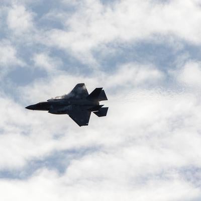 曇り空を背景に飛行する航空自衛隊の戦闘機の写真