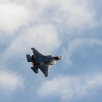 白い雲が浮かぶ青空を飛行する航空自衛隊の戦闘機F-35の写真